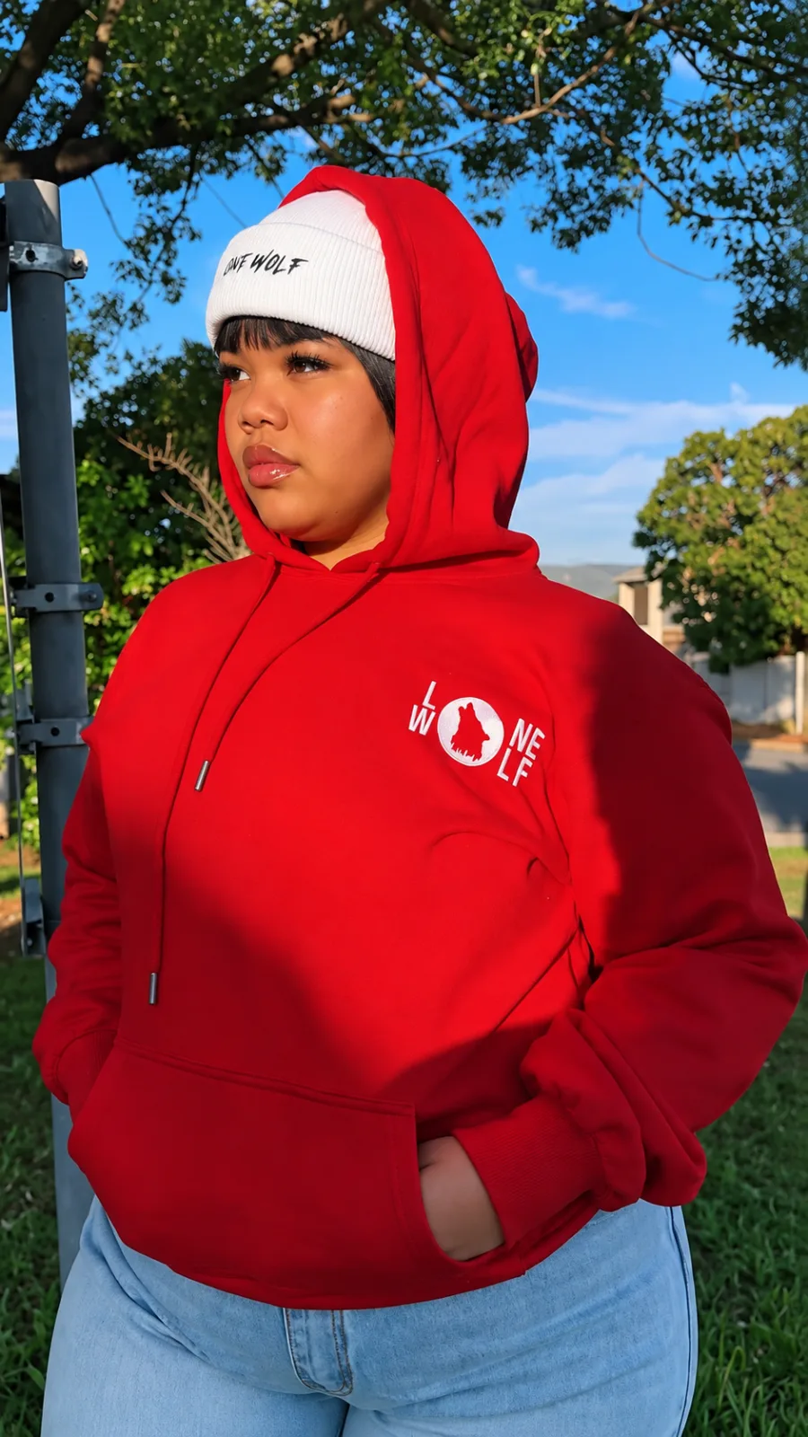 Model wearing a red Lone Wolf emblem hoodie and a white beanie